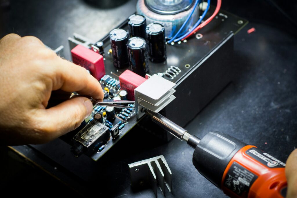 blaz-erzetic-g5f0BJq-FRs-unsplash „Fachmännische Reparatur einer Leiterplatte mit präziser Bauteil-Montage und Kühlkörper-Installation.“